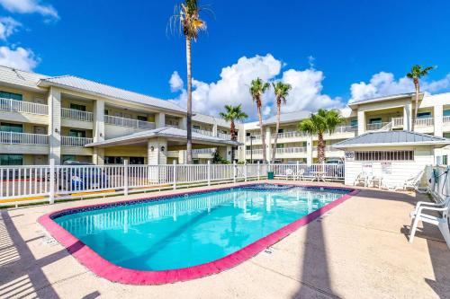 a swimming pool in front of a building with palm trees at Studio 6-Corpus Christi, TX - North in Corpus Christi