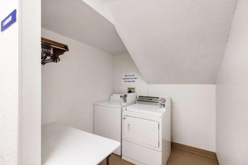a small white laundry room with a washer and dryer at Motel 6-Olathe, KS in Olathe