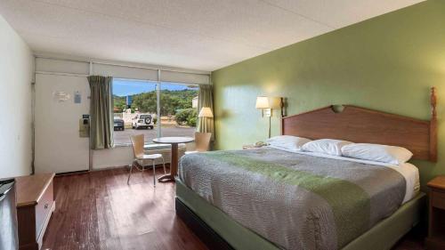 ein Hotelzimmer mit einem großen Bett und einem Tisch in der Unterkunft Motel 6-Pulaski, TN in Pulaski
