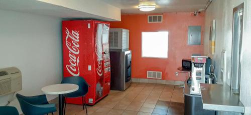 Habitación con nevera de coca cola y mesa en Motel 6-Goodland, KS, en Goodland