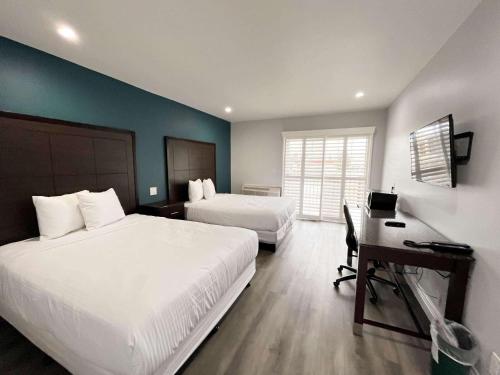 1 dormitorio con 2 camas y escritorio con ordenador en Motel 6 Vallejo, CA - Napa Valley en Vallejo