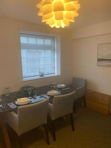 a dining room with a table and chairs and a chandelier at Gorgeous seaside getaway. in Hastings