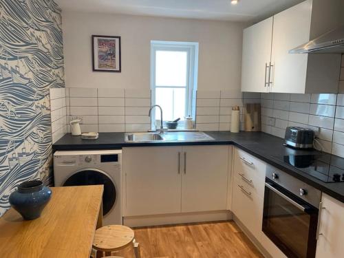 a kitchen with a sink and a dishwasher at Gorgeous seaside getaway. in Hastings