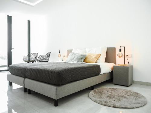 1 dormitorio con 1 cama grande con alfombra en Filomena Apartments LUXURY en Mindelo