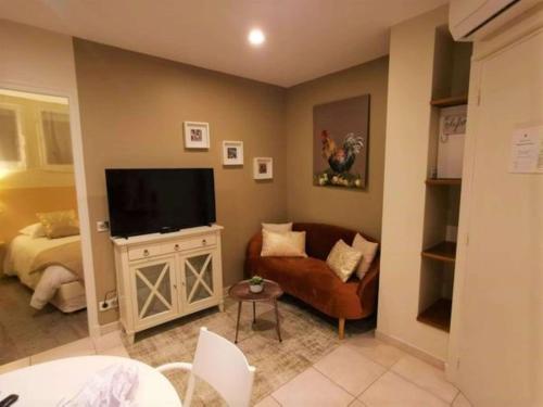 ein Wohnzimmer mit einem Sofa und einem Flachbild-TV in der Unterkunft Best Western Grand Hotel de Bordeaux in Aurillac