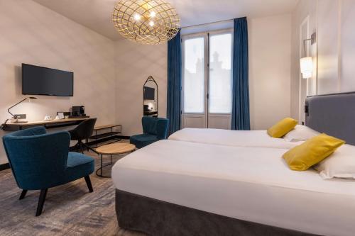 una camera d'albergo con un grande letto e una scrivania di Best Western Urban Hotel a Lille