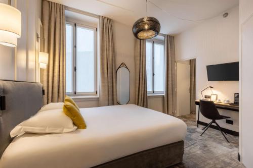 a hotel room with a large bed and a desk at Best Western Urban Hotel in Lille