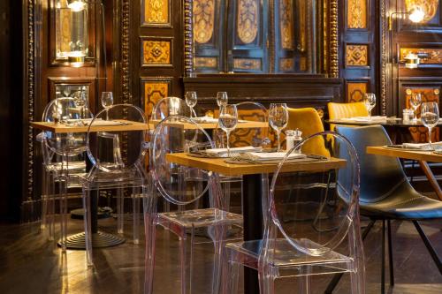 a dining room with tables and chairs with wine glasses at Best Western Urban Hotel in Lille