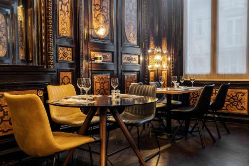 a restaurant with two tables and chairs with wine glasses at Best Western Urban Hotel in Lille