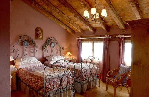 a bedroom with two beds and a chandelier at Maso Di Villa Relais di Campagna in Susegana