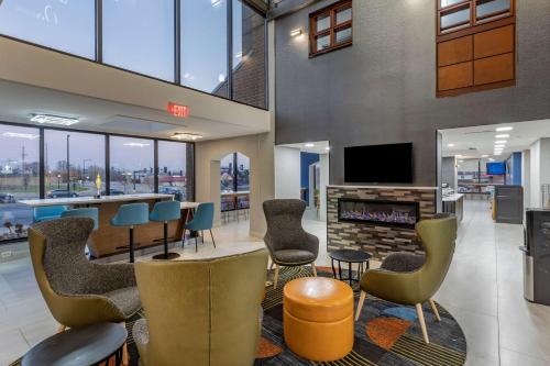 a lobby with a bar with chairs and a fireplace at Best Western Plus St. Louis West-Westport in Maryland Heights