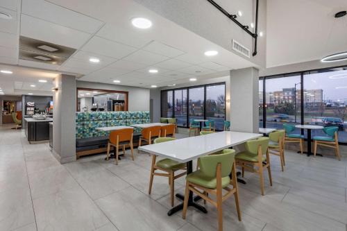 a dining room with tables and chairs and windows at Best Western Plus St. Louis West-Westport in Maryland Heights