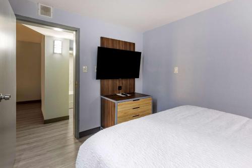 a bedroom with a bed and a flat screen tv at Best Western Plus St. Louis West-Westport in Maryland Heights