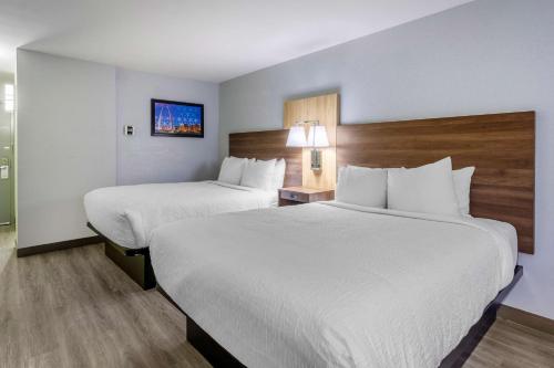 a hotel room with two beds with white sheets at Best Western Plus St. Louis West-Westport in Maryland Heights