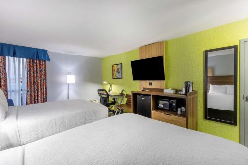 um quarto de hotel com duas camas e uma televisão de ecrã plano em Best Western Plus St. Louis West-Westport em Maryland Heights