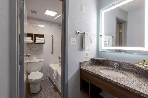 a bathroom with a sink and a toilet and a mirror at Best Western Plus St. Louis West-Westport in Maryland Heights