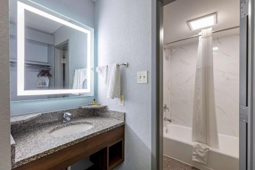 a bathroom with a sink and a mirror and a tub at Best Western Plus St. Louis West-Westport in Maryland Heights