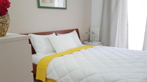 a bedroom with a bed with a yellow and white blanket at Ferienwohnung-Ginkgo-A3 in Banjole