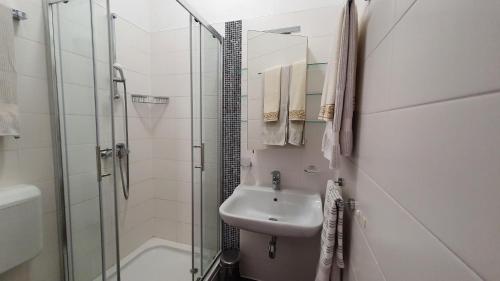 a white bathroom with a sink and a shower at Ferienwohnung-Ginkgo-A3 in Banjole