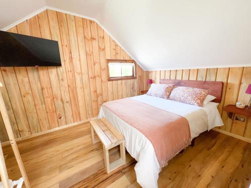 Schlafzimmer mit einem Bett und einem Flachbild-TV in der Unterkunft Agua y Campo Hotel Boutique in Osorno