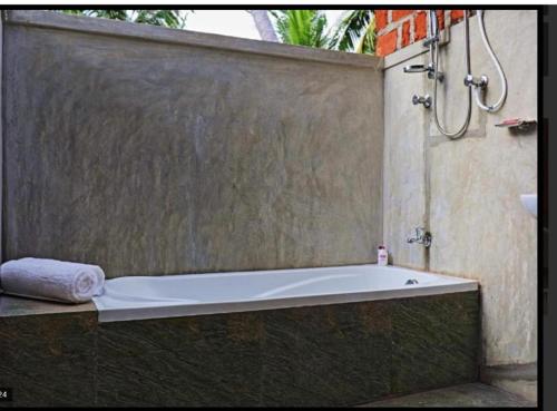 a bath tub in a shower with a towel at THE HIDEOUT KURUNEGALA in Kurunegala
