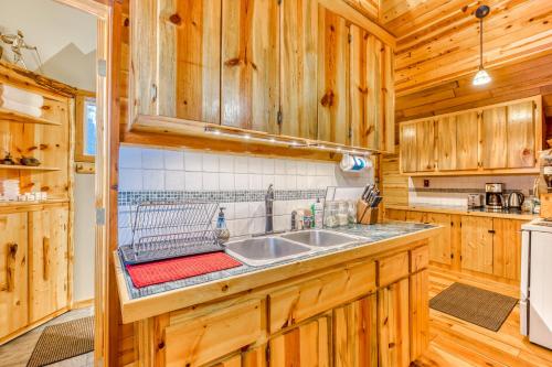 una cocina con armarios de madera y fregadero en Cedar Cabin, en Welches
