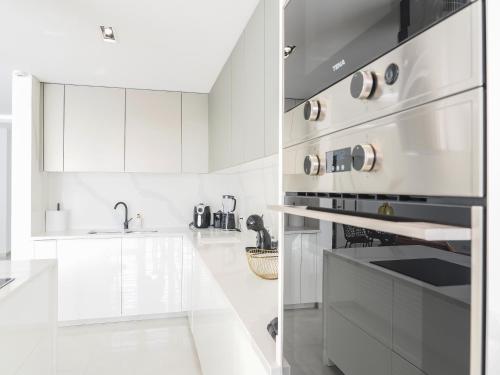 a white kitchen with a stove and a sink at Filomena Apartments BOHÈME in Mindelo