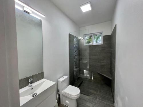 Baño blanco con aseo y lavamanos en The Indianna ~ Luxury Pool & Spa en Whitehouse