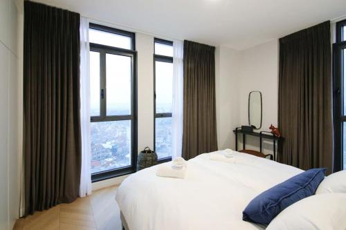 una camera con due letti bianchi e ampie finestre di Amazing View...2 bedroom apt J tower a Gerusalemme