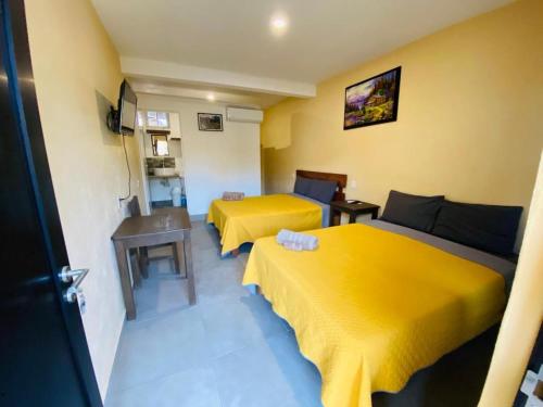 2 camas en una habitación con sábanas amarillas en HOTELITO SAN IGNACIO, en San Ignacio