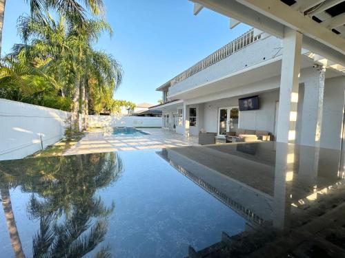 a pool of water in front of a building at Spacious and Luxurious 4bd 3br House Pool Tub BBQ Private in Miami