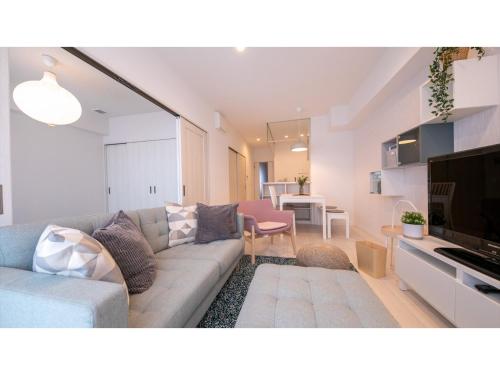 a living room with a couch and a tv in a room at Hotel Best Price Kochi - Vacation STAY 17532v in Kochi
