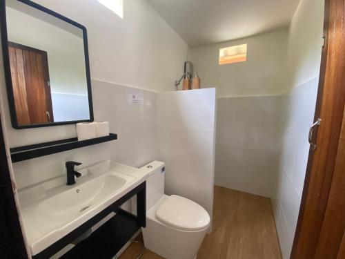 a white bathroom with a sink and a toilet at The Mellow Mango in Ko Lanta