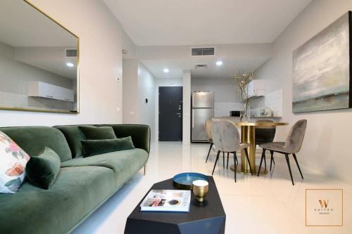 a living room with a green couch and a table at Gorgeous 1 bedroom apt , J Tower in Jerusalem