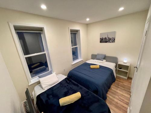 1 dormitorio pequeño con 2 camas y 2 ventanas en Elegant Private Room close to Manhattan! - Room is in a 2 bedrooms apartament and first floor with free street parking, en Long Island City