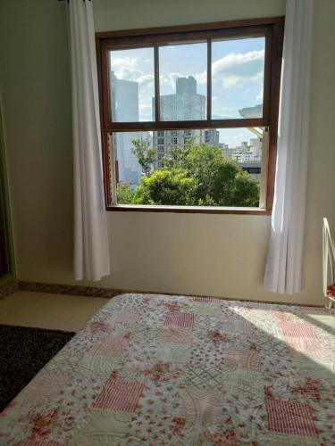 1 dormitorio con ventana y 1 cama con alfombra en Espaço Inteiro para 08 pessoas próximo a área hospitalar em BH, en Belo Horizonte