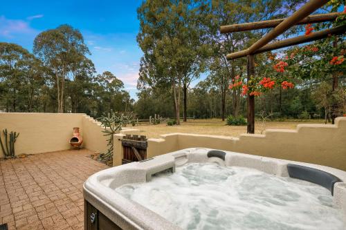 a hot tub on a patio in a yard at Casa La Vina Villas Pokolbin in Pokolbin