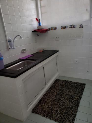 a bathroom with a sink and a rug next to it at Espaço Inteiro para 08 pessoas próximo a área hospitalar em BH in Belo Horizonte