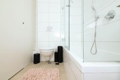 een badkamer met een douche en een roze tapijt bij Lovely 2 bedroom apt. Haneviim boutique in Jeruzalem