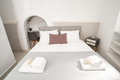um quarto com uma grande cama branca com toalhas em Lovely 2 bedroom unit, Shivtey Israel, Jerusalem em Jerusalém