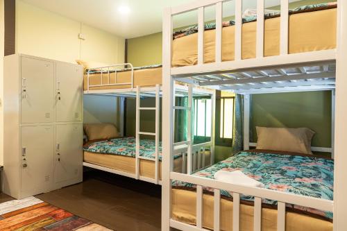 Pokój z 2 łóżkami piętrowymi i łóżkiem w obiekcie Blockhouse Hostel w mieście Ban Na We