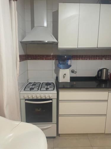 a small kitchen with a stove and white cabinets at Manolo in Santa Rosa