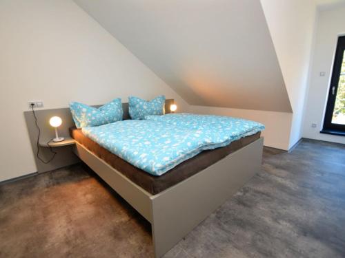 a bedroom with a bed with blue pillows on it at Beautiful Holiday Home in Bohemian near Forest in Železná Ruda