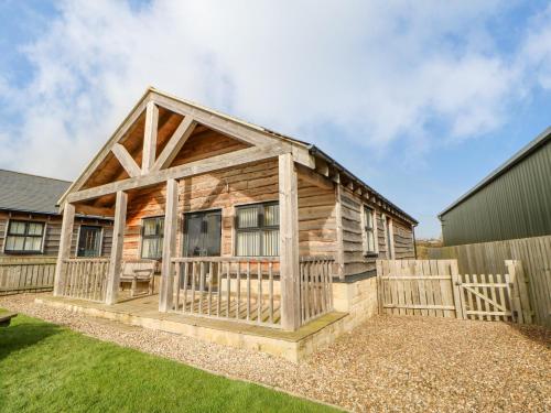 a log cabin with a fence in the yard at Wansbeck in Longframlington