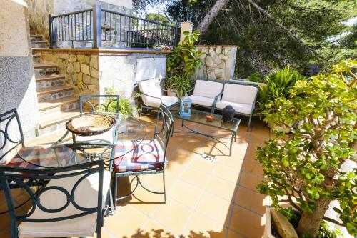 a patio with chairs and a glass table on a patio at Buda Villa Planetcostadorada in Salou