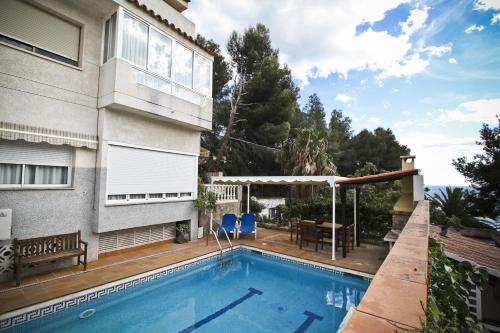 a swimming pool in front of a house at Buda Villa Planetcostadorada in Salou