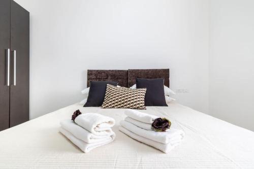 sypialnia z białym łóżkiem i ręcznikami w obiekcie Luxury 3 bedroom apt, Harav Kook7 w Jerozolimie