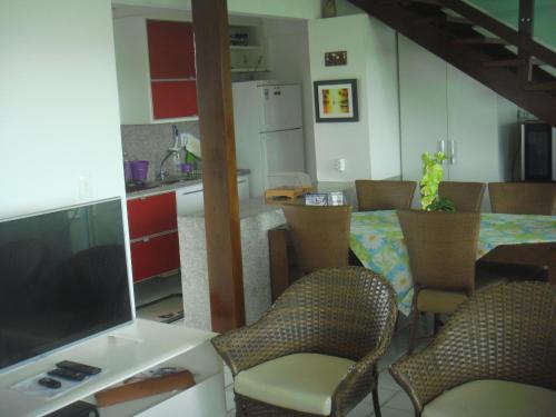 eine Küche und ein Esszimmer mit Tisch und Stühlen in der Unterkunft Ancorar Porto de Galinhas in Porto De Galinhas