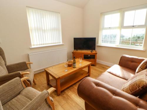 a living room with two couches and a television at Coquet in Longframlington