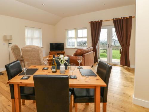 a dining room with a wooden table and chairs at Coquet in Longframlington